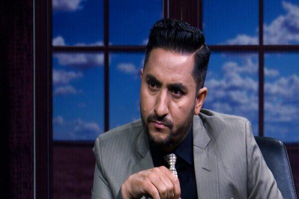 Jagadish Kharel seated in a suit with a serious expression during an interview setting.