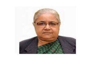 Sushila Karki, wearing glasses and a green patterned blouse, poses for a formal portrait.