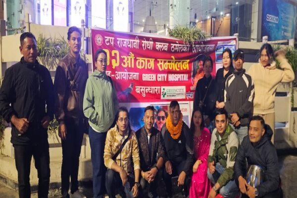 A group of individuals posing together at a public event with a banner in the background.