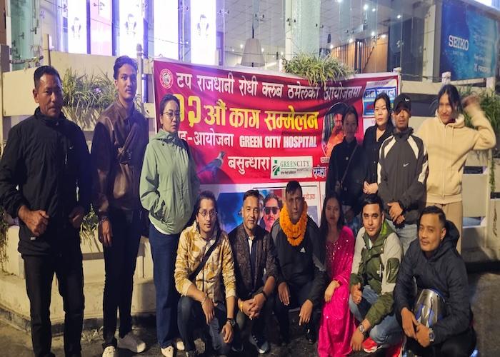 A group of individuals posing together at a public event with a banner in the background.