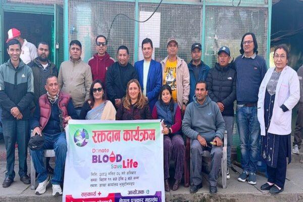 Group of individuals participating in a blood donation event, holding a banner that promotes blood donation.